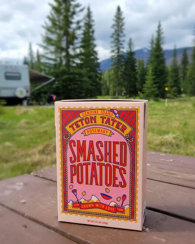A Teton Tater carton on a picnic table at a mountain campsite